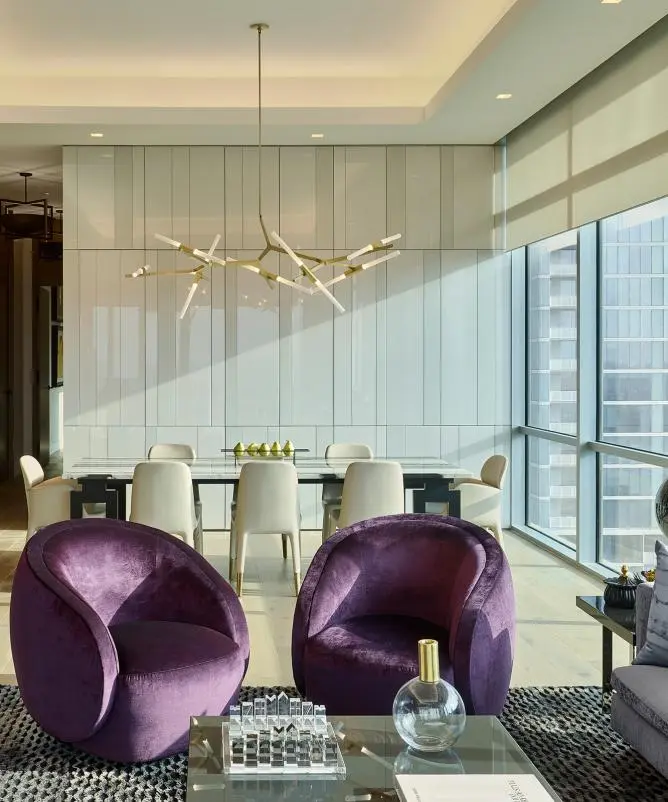 Living and dining room with Lutron roller shades partly lowered over floor-to-ceiling windows